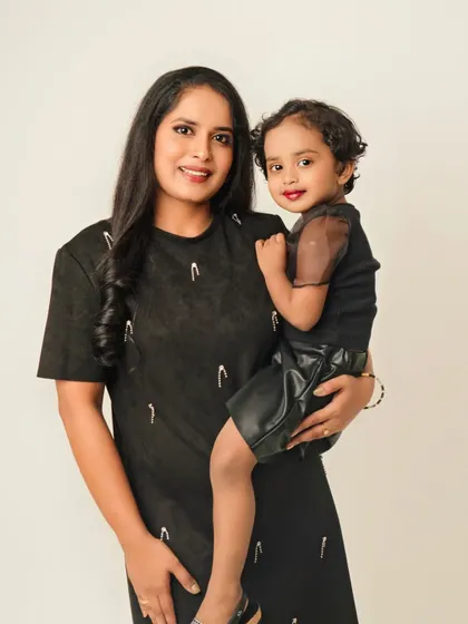 A mother and daughter portrait that is both sweet and stylish. The simple white background allows their connection and matching outfits to be the main focus.