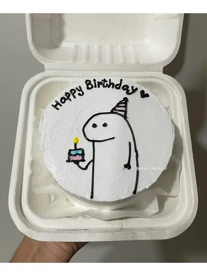 A classic "flork of cows" meme character holding a birthday cake, drawn on a bento.