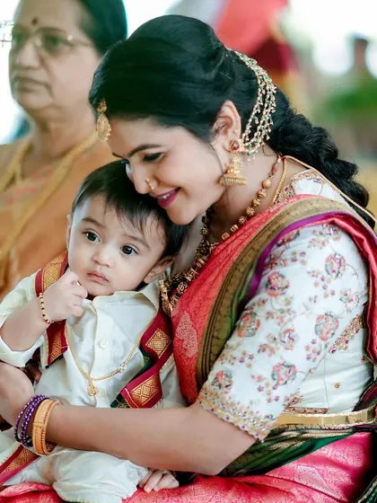 A heartwarming moment between a mother and her child. She is wearing a custom white blouse with floral embroidery, showing that my designs are perfect for all of life's special occasions.