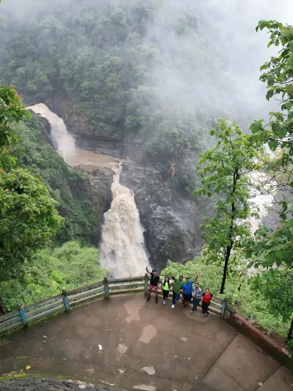 Our group at a viewpoint overlooking a massive, muddy waterfall during the peak monsoon. The power of nature is on full display here.