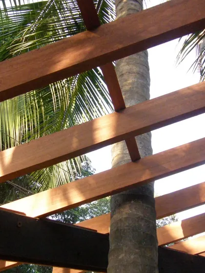 A palm tree is carefully integrated into the structure of K-Lagoon. The wooden beams of the pergola are notched to accommodate the trunk, a small but significant detail that shows our respect for the existing nature.