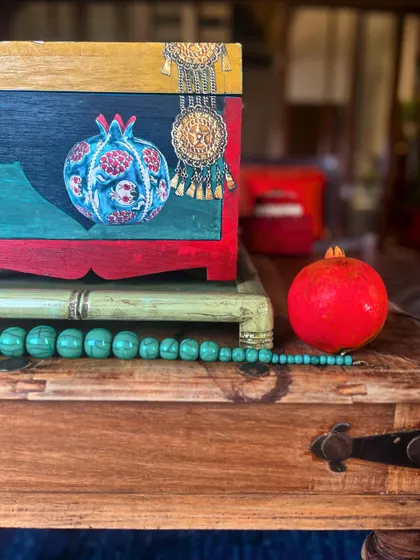 The other side of the box, featuring a hand-painted pomegranate and a decorative jewelry element, blending different cultural inspirations into a cohesive design.