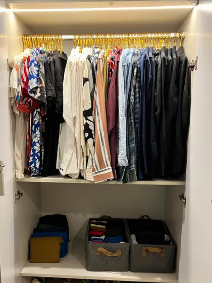 A wardrobe that is both organized and easy on the eyes. This is achieved with matching hangers, color coding, and a mix of hanging and folded storage.