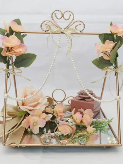 For a truly romantic and whimsical ring ceremony, I designed this swing-style platter. The rings are placed on a mirrored base, adorned with delicate pearls and soft peach roses.