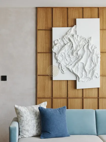 A close-up of the textured wall art against the gridded wood paneling. This juxtaposition of soft, organic sculpture and rigid geometric lines is a key theme throughout the home.