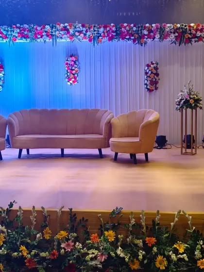 This is the same stage setup for a corporate event, showing the full view with the floral border at the base of the stage. I use fresh, colorful flowers to frame the stage and add life to the setting.