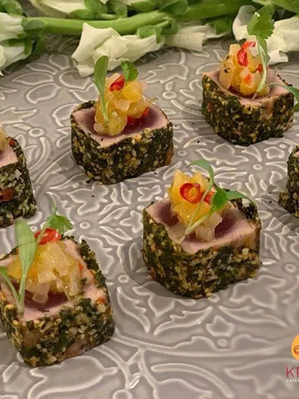 For our Pan-Asian menus, we offer items like this herb-crusted seared tuna. It's topped with a zesty pineapple salsa, creating a refreshing and complex flavor profile for your guests.