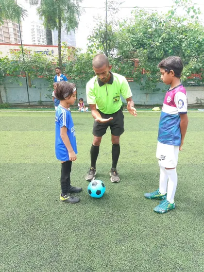 A referee gives instructions to our young U-7 captain before a match. These moments are important learning experiences for our future leaders.