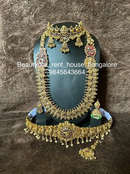 This antique bridal set features a Lakshmi choker and a mango-motif long necklace, available for rent with a matching vaddanam.