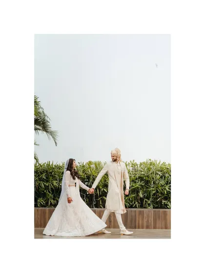 A playful and romantic shot of the couple holding hands and walking together. The wide-angle view gives a sense of freedom and joy, capturing their journey into a new life.
