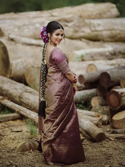 A full-length shot of the bride in her beautiful saree, her long braided hair and traditional jewelry completing the classic look.