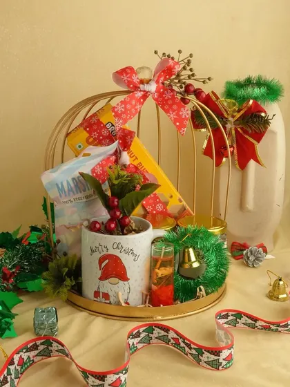 A golden birdcage filled with Christmas goodies. This unique presentation includes a festive mug and snacks, making it a standout gift.