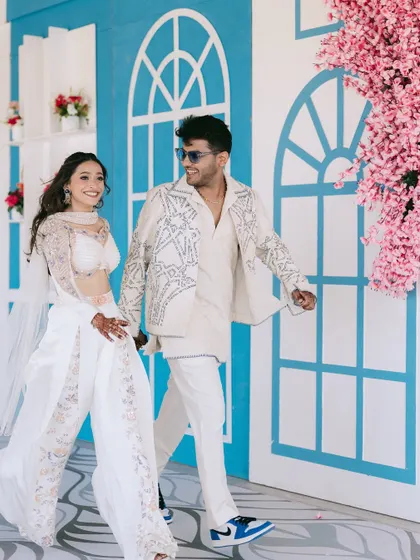 A happy, candid shot of the couple walking hand-in-hand. Their smiles and the colorful decor create a vibrant and joyful image that perfectly captures the mood of the day.