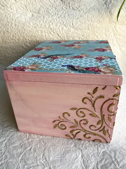 The back of the jewelry box, showing the hand-painted pink finish and the gold stenciling on the corner.