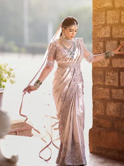 The bride looks breathtaking in her custom-designed saree and blouse. The flowing veil adds a touch of drama and romance to her look.
