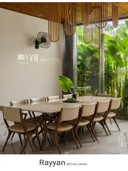The ten-seater dining table at Rayyan is set against a floor-to-ceiling window, offering diners an immersive view of the tall, lush plants in the adjacent lightwell.