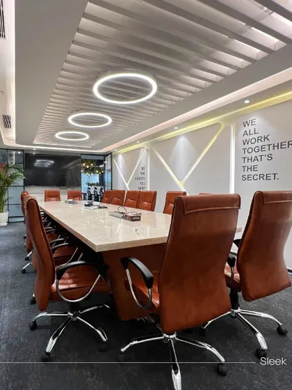 The main boardroom at Rays Power, designed for executive meetings. The space features a large marble-topped table, comfortable leather chairs, and modern ring lighting, with a motivational quote on the wall to inspire teamwork.