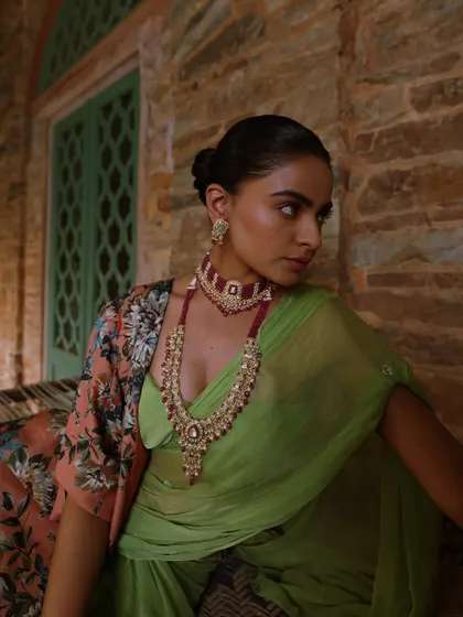 A serene yet opulent look from a heritage jewellery campaign. I styled a lime green saree with a floral cape and a stunning ruby choker and necklace set, creating a beautiful contrast against the rustic stone architecture.