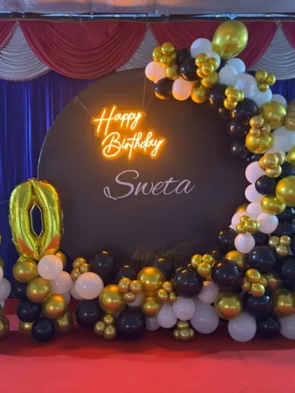 This angle highlights the glowing neon sign and the custom name 'Sweta' on the backdrop for the 50th birthday party.
