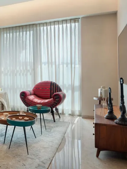 A pop of color can define a room. This vibrant, patterned armchair becomes the focal point in an otherwise serene living space, demonstrating how a single piece of furniture can bring energy and personality to a design.