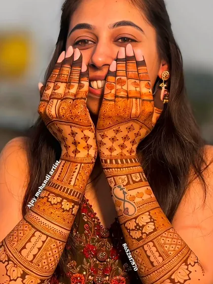 A classic "face-hiding" pose that puts the beautiful, intricate mehndi front and center.