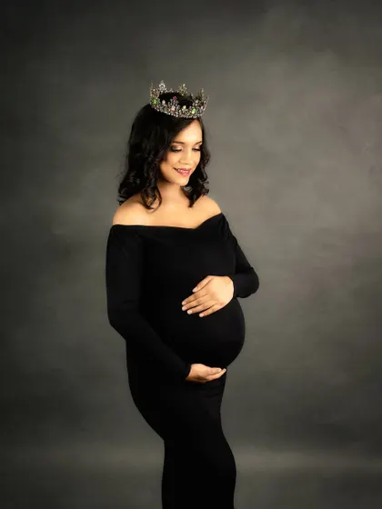Every mother is a queen, and sometimes she needs a crown to match. This classic, elegant portrait in a black gown shows how a simple prop can add a touch of regal grace to your maternity photos.