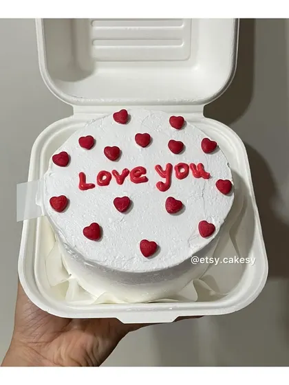 A classic "Love you" bento cake with red hearts on a clean white frosting.