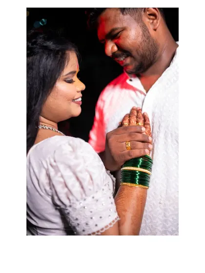 A sweet moment between the couple, highlighting the bride's traditional green bangles. This portrait combines romance with important cultural details of a Maharashtrian engagement.