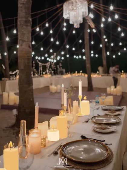 A beautifully set dinner table, glowing with an abundance of candles, creating a warm, intimate, and incredibly romantic atmosphere.