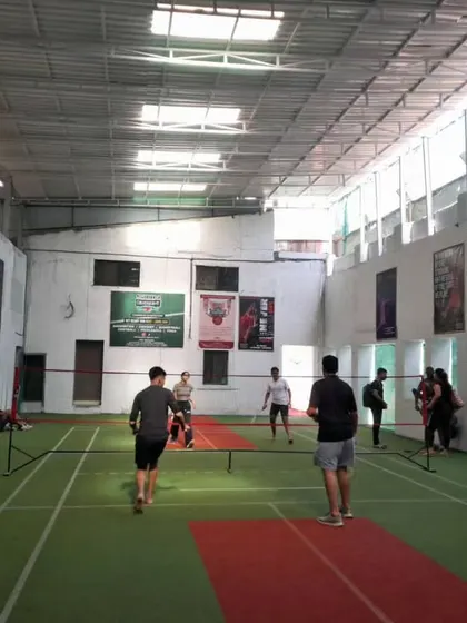 A full view of the court with players warming up. There's plenty of room to move and play freely.