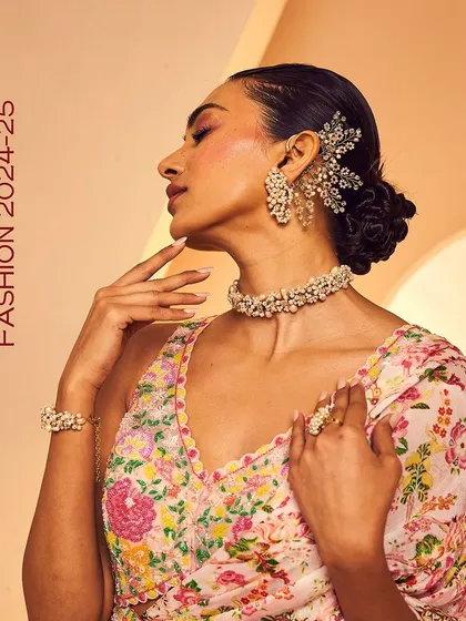 A complete festive look featuring our pearl earcuff, choker, bracelet, and ring set against a floral lehenga.