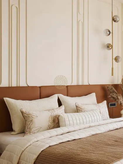 In this Mumbai duplex, the master bedroom features a warm tan leather headboard against a wall with elegant white paneling. The simple, clean lines create a calm and restful environment.