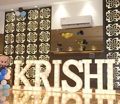 Large marquee letters spelling "KRISHIV" at a Boss Baby themed party.