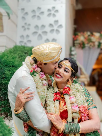 A sweet kiss on the cheek, a candid moment of affection between the newly married couple.