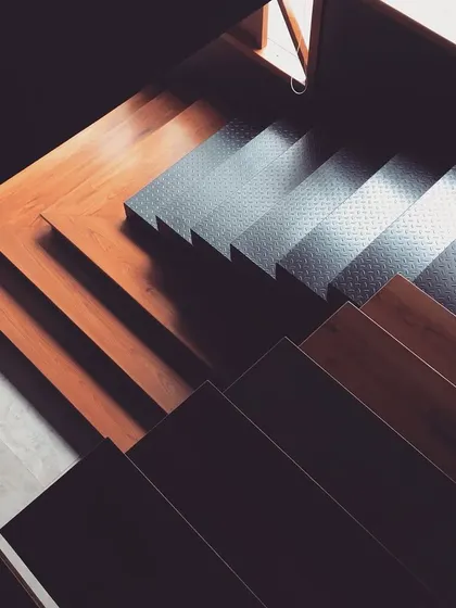 A detail shot of a staircase where different materials meet. We combined dark wood treads with textured metal risers to create a sharp, modern look with an industrial touch.
