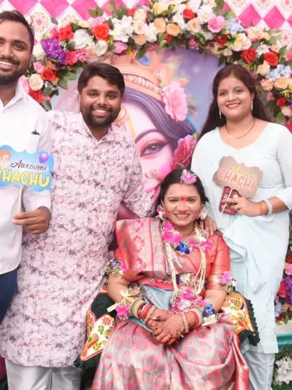 A smiling group of friends and family celebrating together at the Krishna-themed baby shower.