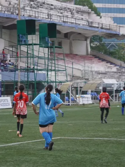 The game unfolds on the pitch, with players from both teams fighting for every inch of ground.