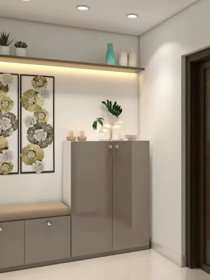 A simple and elegant entryway unit with a seating bench and a closed shoe cabinet. The backlit shelf and metallic wall art add a touch of sophistication.