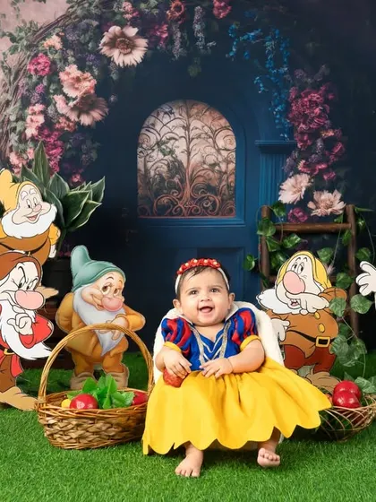 A happy smile from Snow White as she sits with a basket of apples.