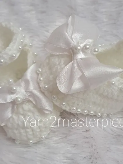 A close-up view of the satin bow booties, showing how the pearls are carefully stitched along the strap for a touch of sparkle.