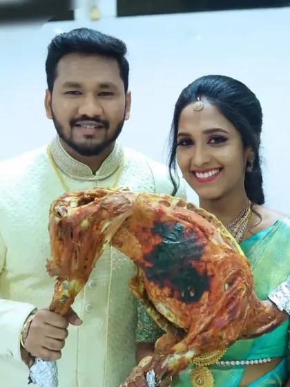 A smiling couple posing with our signature whole roasted mutton.