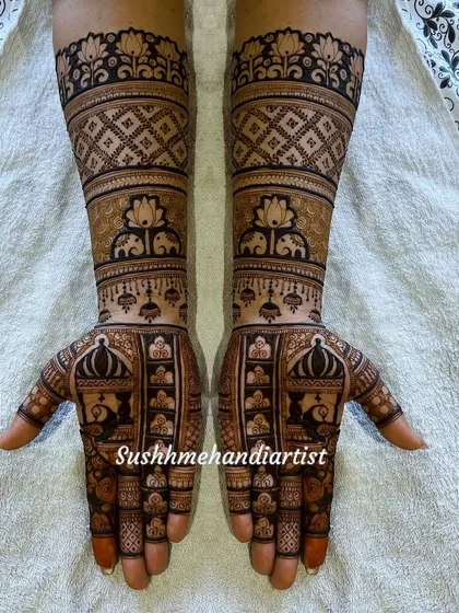 A classic bridal design with peacocks on the palms and elephants on the forearms. The use of lotus motifs and jaali patterns fills the hands beautifully.