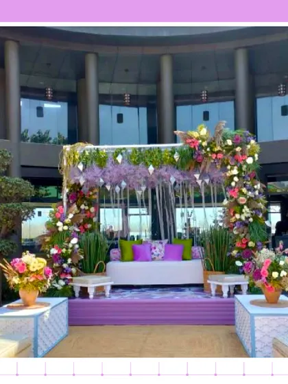 A lovely Mehendi stage in Jim Corbett, with purple and green decor that complements the natural surroundings.