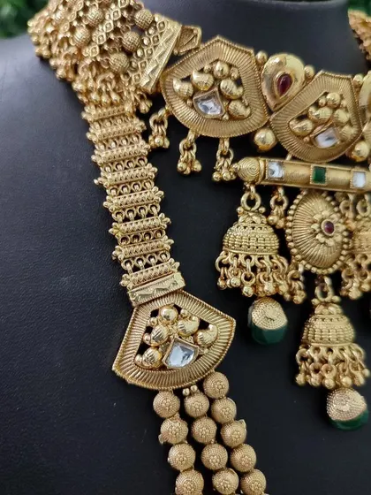 A detailed shot of an antique-finish temple jewellery necklace. This rental piece features intricate carvings and motifs for an authentic, traditional feel.