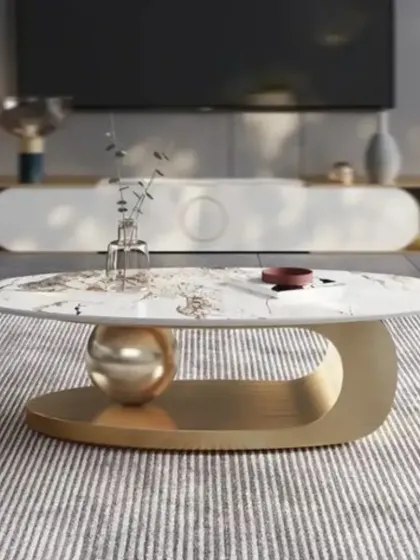 A minimalist yet chic center table with a marble-patterned top and a sculptural gold base. It is paired with a simple, modern TV console in the background.
