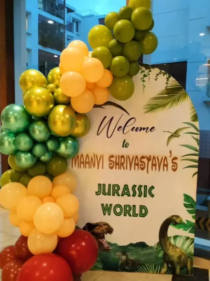 The personalized welcome sign for the Jurassic World party, framed by a matching balloon arrangement.
