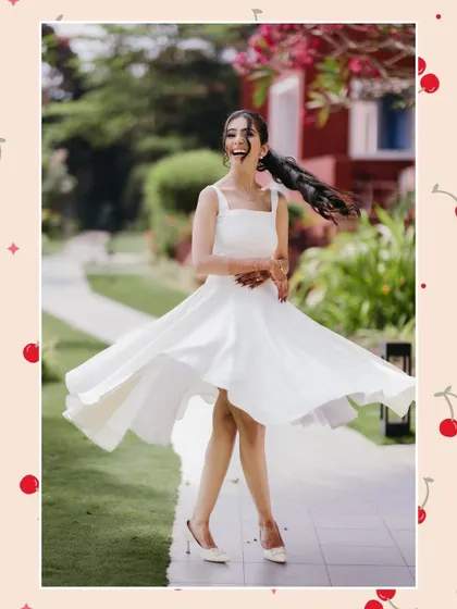 A joyful, twirling shot of a woman in a white dress, her ponytail flying, set against a fun, cherry-patterned background.