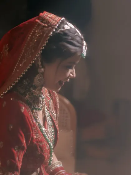A soft-focus, dreamy portrait of the bride, capturing a candid smile. The gentle lighting gives the photo a romantic and ethereal feel.