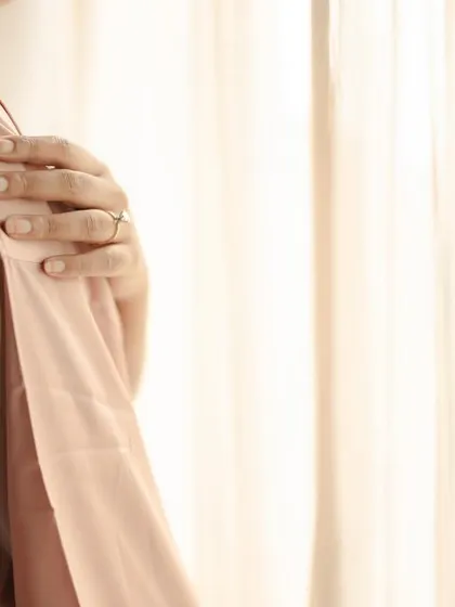 A detailed shot of the bride's hand on her shoulder, a quiet, contemplative moment.