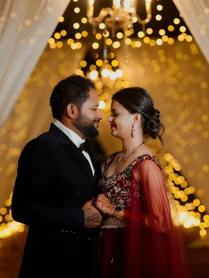 A romantic portrait of a couple at their reception, framed by twinkling lights. The bokeh effect adds a magical and dreamy quality to this intimate moment.